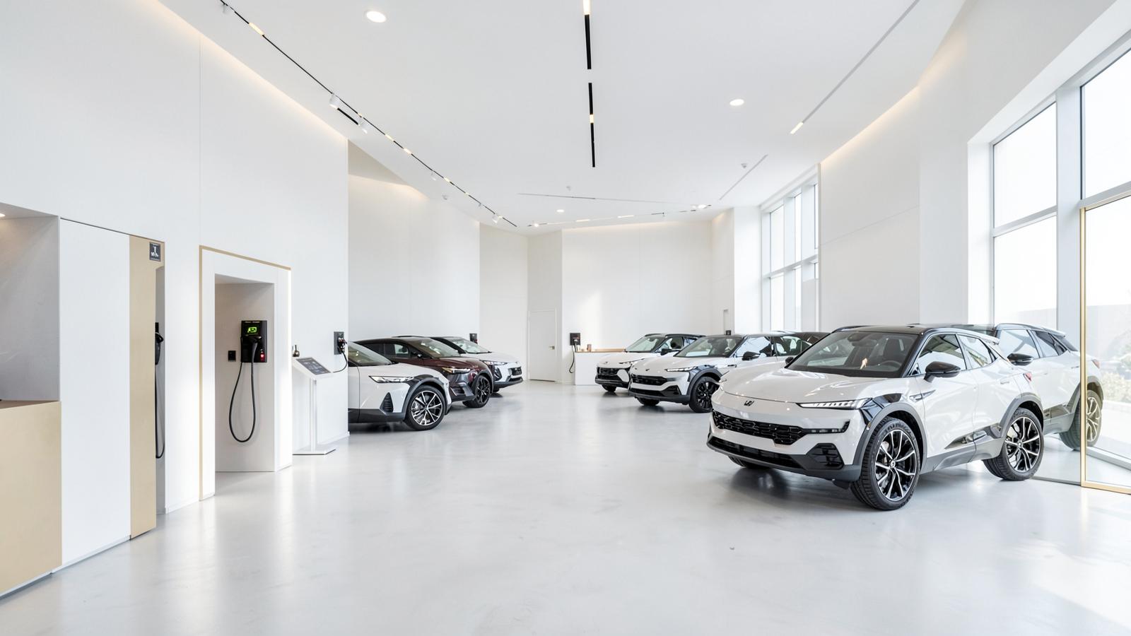Volt Row EV Center white minimal showroom with electric crossovers beside charging stalls