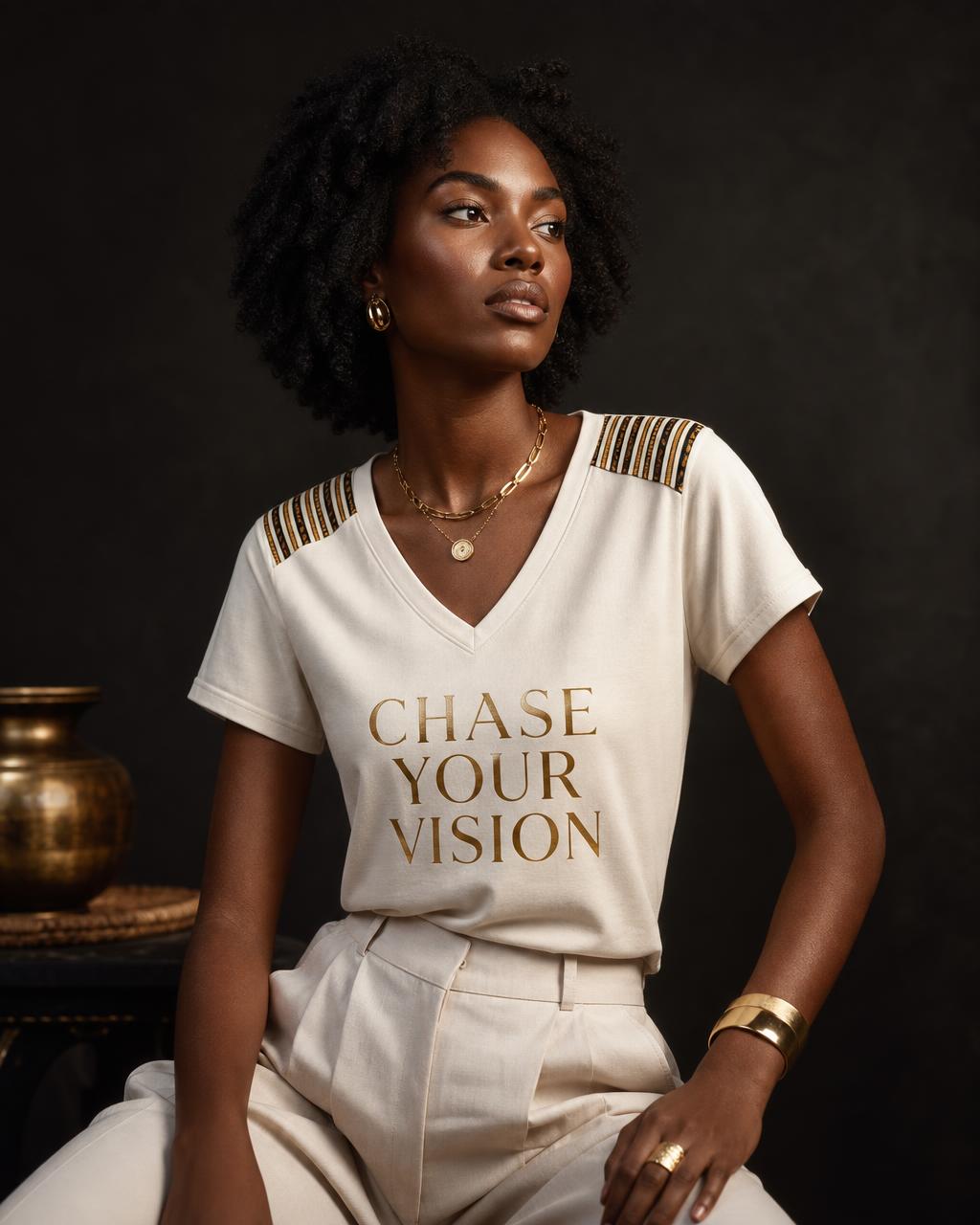 Model wearing the ivory V-neck short-sleeve Chase Your Vision tee with Baoulé stripe shoulders